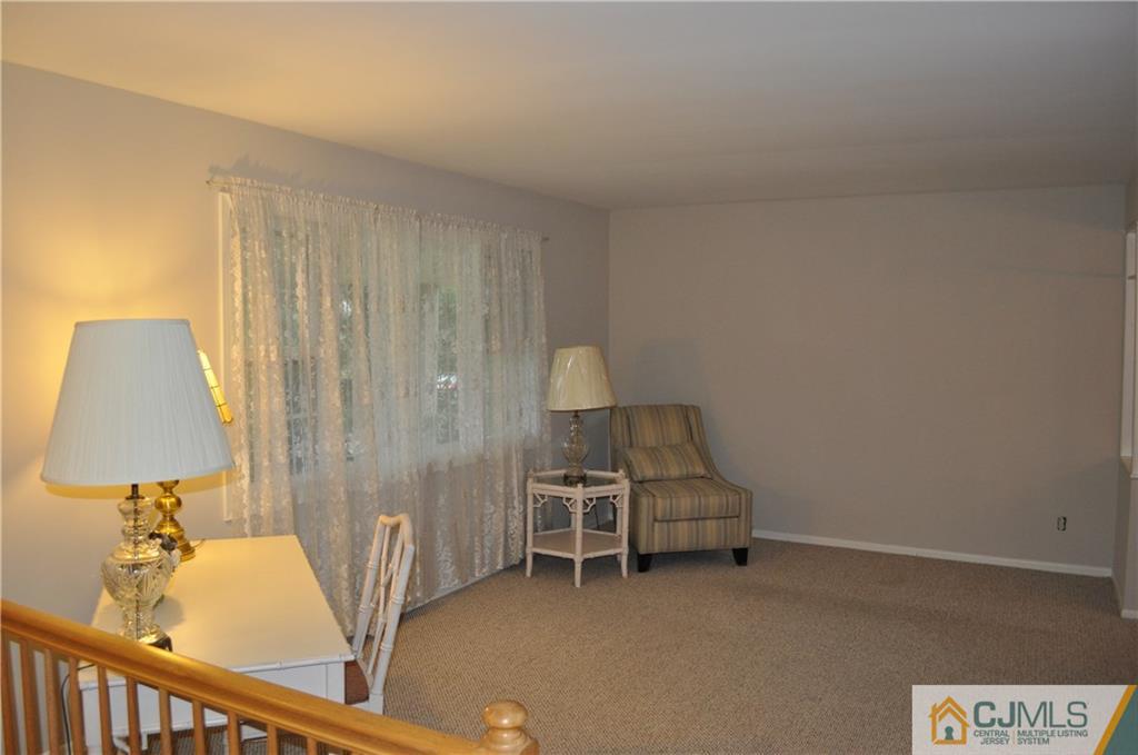 32 Nottingham Road Edison, NJ 08820 - Photo 8 of 25 a living room with furniture and a lamp