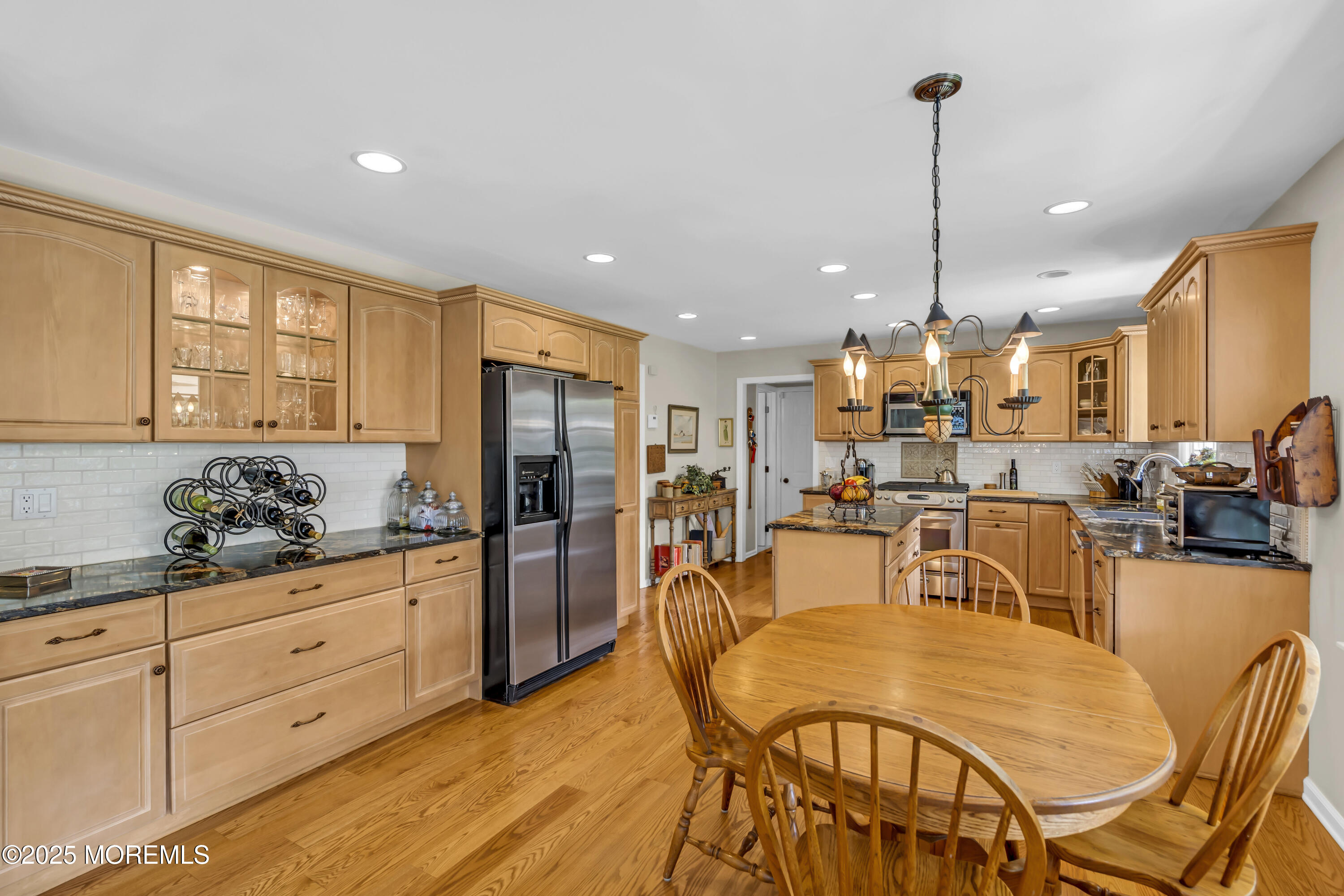664 Valley Road Brielle, NJ 08730 - Photo 24 of 46 a kitchen with stainless steel appliances kitchen island granite countertop a table chairs and a refrigerator