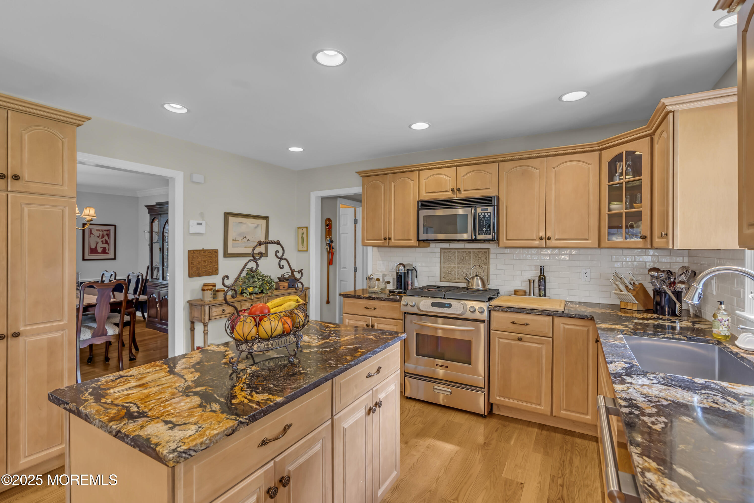 664 Valley Road Brielle, NJ 08730 - Photo 25 of 46 a kitchen with stainless steel appliances granite countertop a stove top oven a sink dishwasher a dining table and chairs with wooden floor