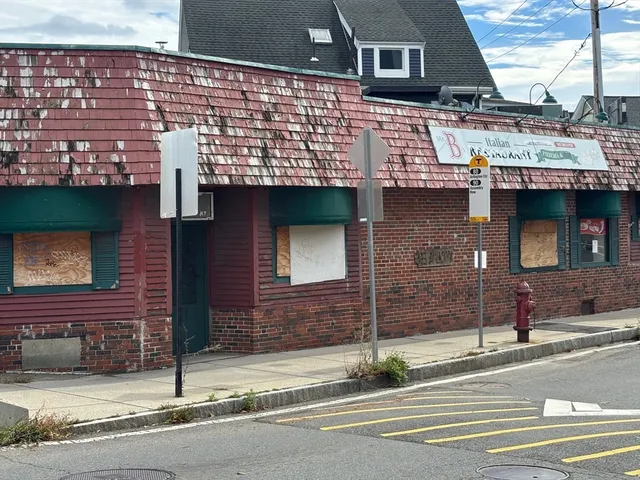 a view of a living room with stainless steel appliances wooden floors