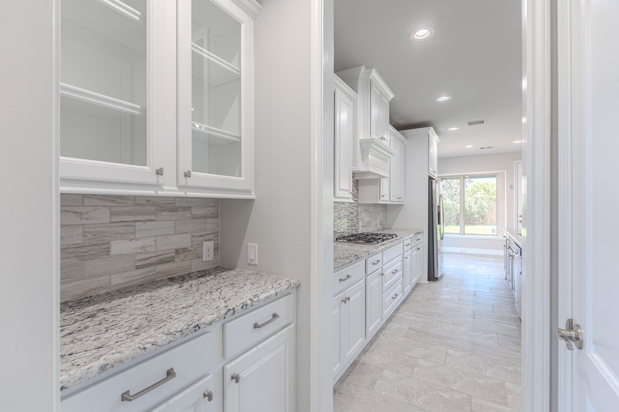27918 Madison Bend Drive Spring, TX 77386 - Photo 11 of 50 a large kitchen with granite countertop a stove and white cabinets