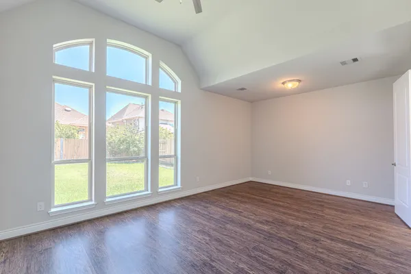 an empty room with a window and a fan
