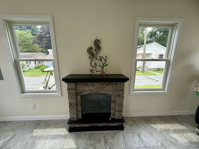 a living room with a fireplace and windows