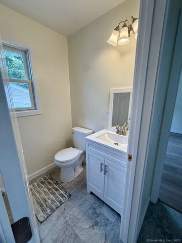 a bathroom with a sink a toilet and mirror