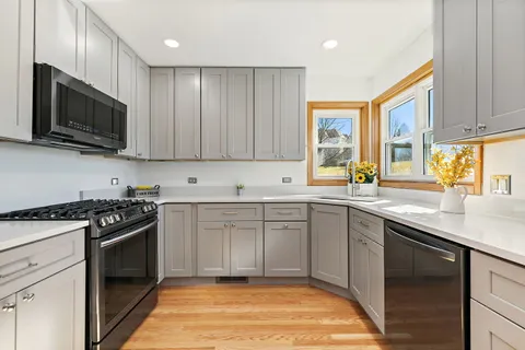 a kitchen with stainless steel appliances granite countertop a stove a sink and a microwave