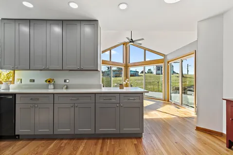a kitchen with a sink window and cabinets