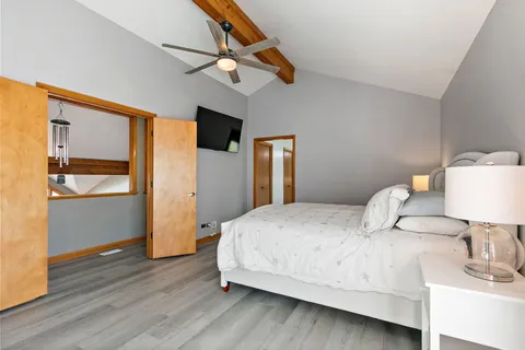 a bedroom with a bed and wooden floor