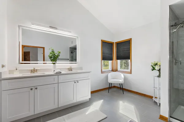 a en suite bathroom with a double vanity sink and a window