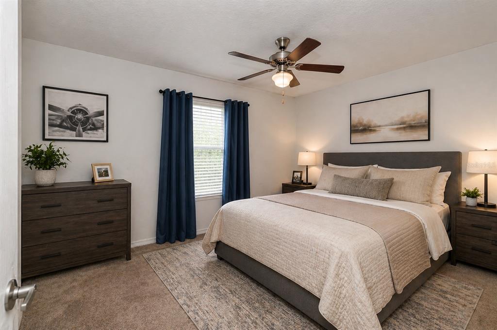 7153 Southeast 124th Street Belleview, FL 34420 - Photo 12 of 16 a bedroom with a bed and a chandelier