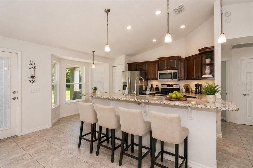 7153 Southeast 124th Street Belleview, FL 34420 - Photo 7 of 16 a kitchen with stainless steel appliances granite countertop a stove top oven a sink refrigerator and cabinets