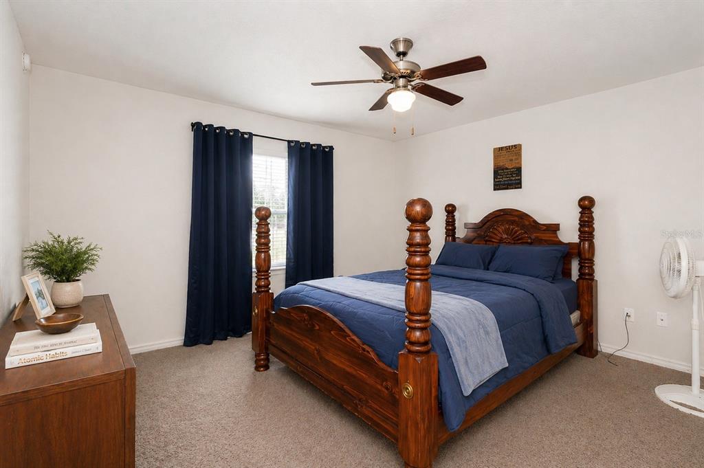 7153 Southeast 124th Street Belleview, FL 34420 - Photo 8 of 16 a bed room with a bed and a potted plant