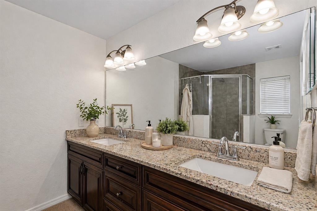 7153 Southeast 124th Street Belleview, FL 34420 - Photo 9 of 16 a bathroom with a granite countertop double vanity and a mirror