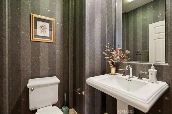 a bathroom with a sink a toilet and mirror