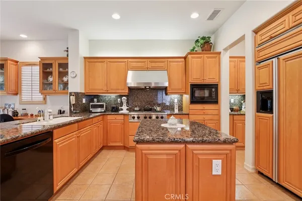 a kitchen with stainless steel appliances granite countertop a stove sink and cabinets