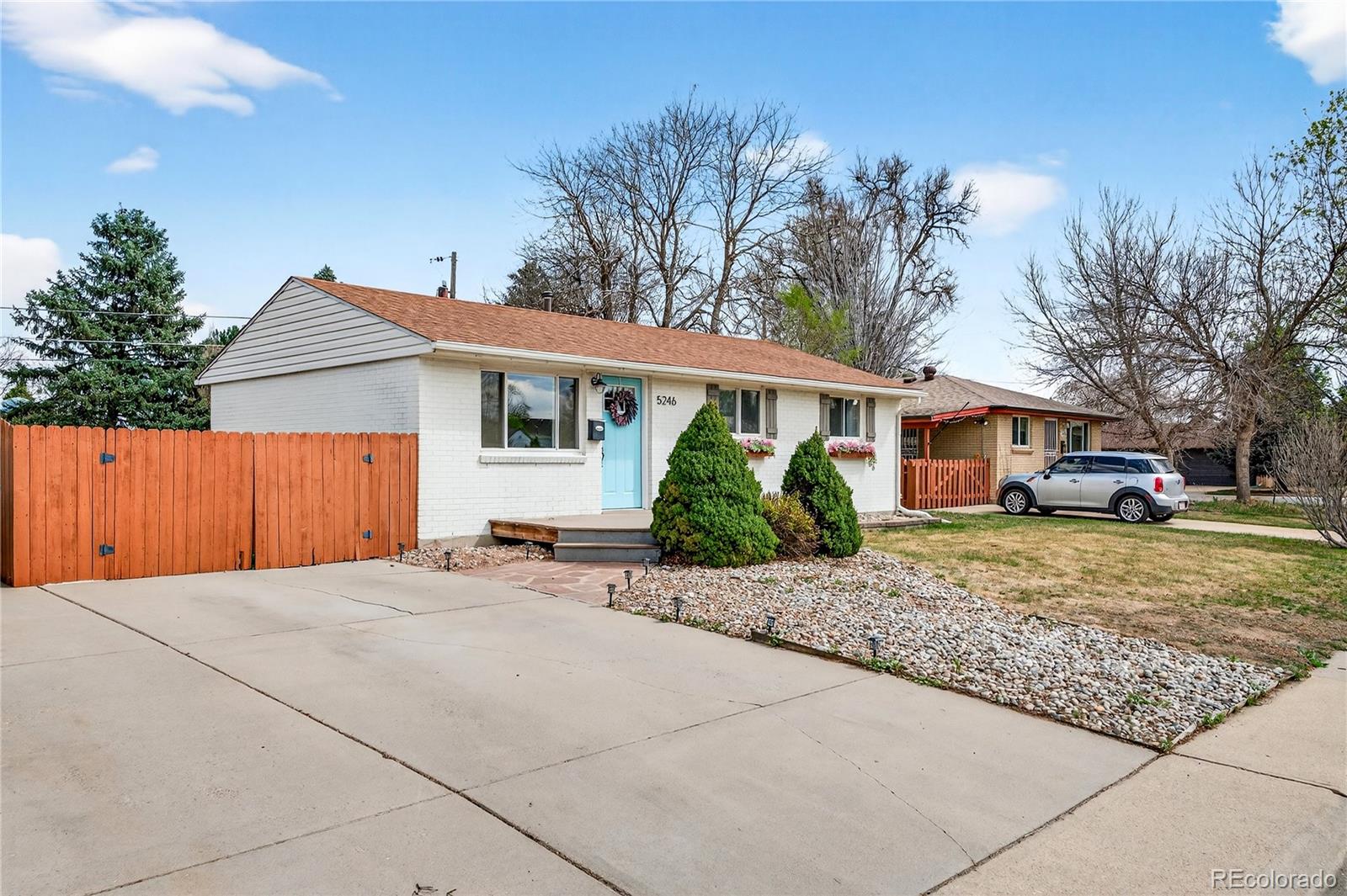 5246 Pierce Street Arvada, CO 80002 - Photo 15 of 30 a front view of a house with a garden and trees