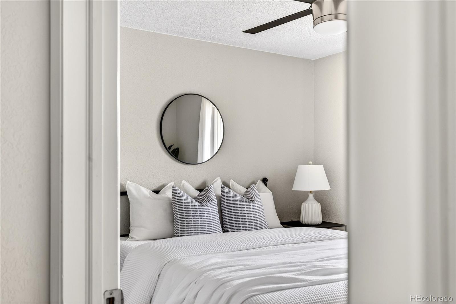 5246 Pierce Street Arvada, CO 80002 - Photo 24 of 30 a bed room with furniture and a mirror