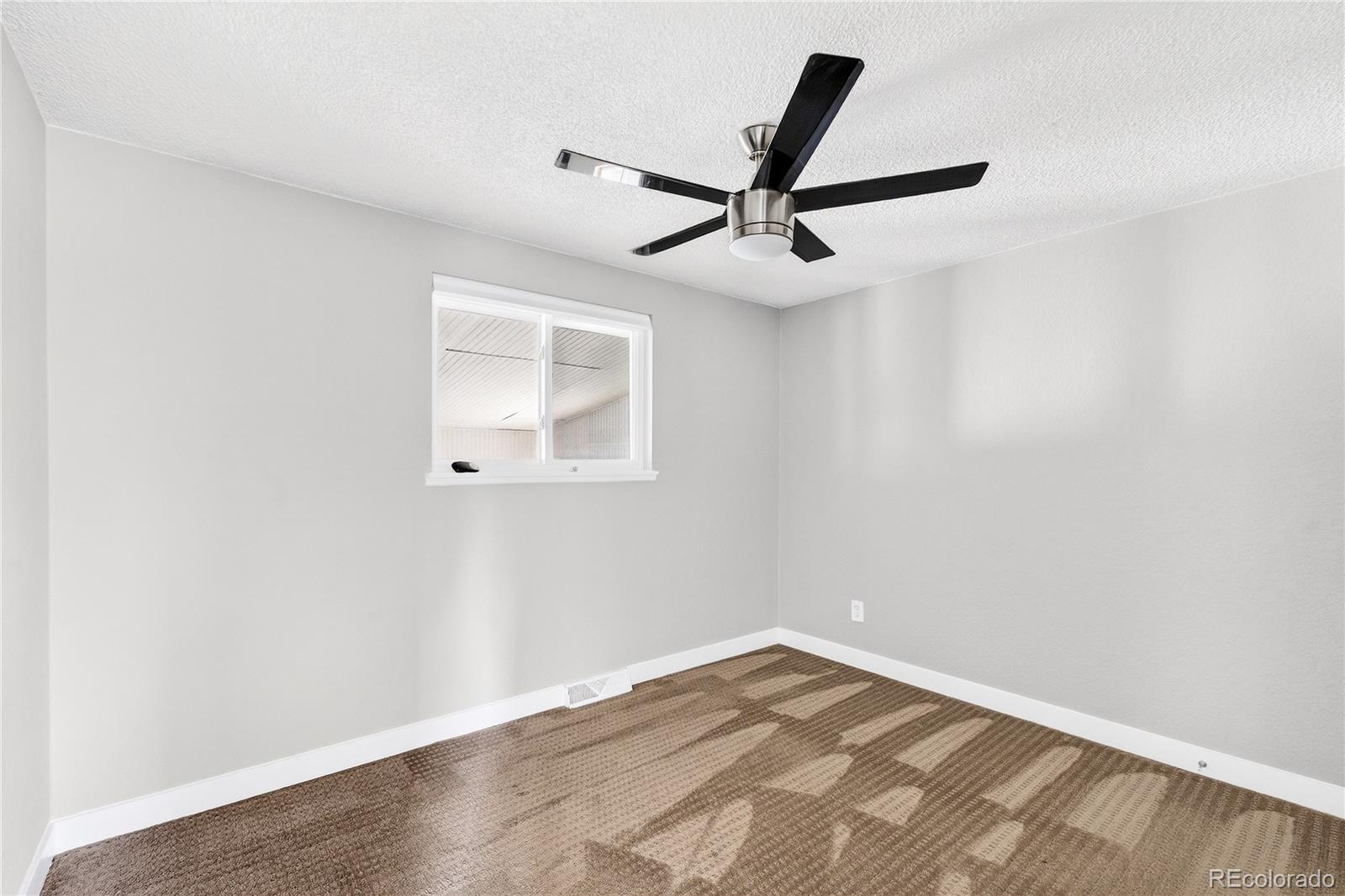 5246 Pierce Street Arvada, CO 80002 - Photo 25 of 30 an empty room with a window and a ceiling fan