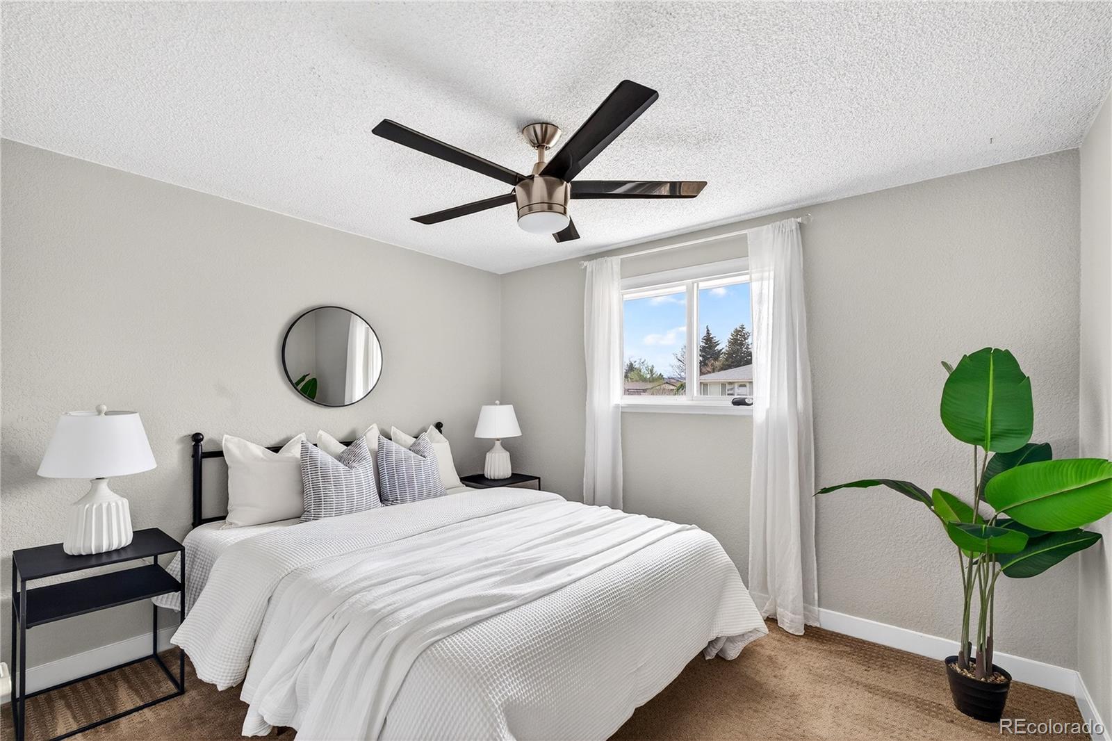 5246 Pierce Street Arvada, CO 80002 - Photo 9 of 30 a bedroom with bed and a chandelier