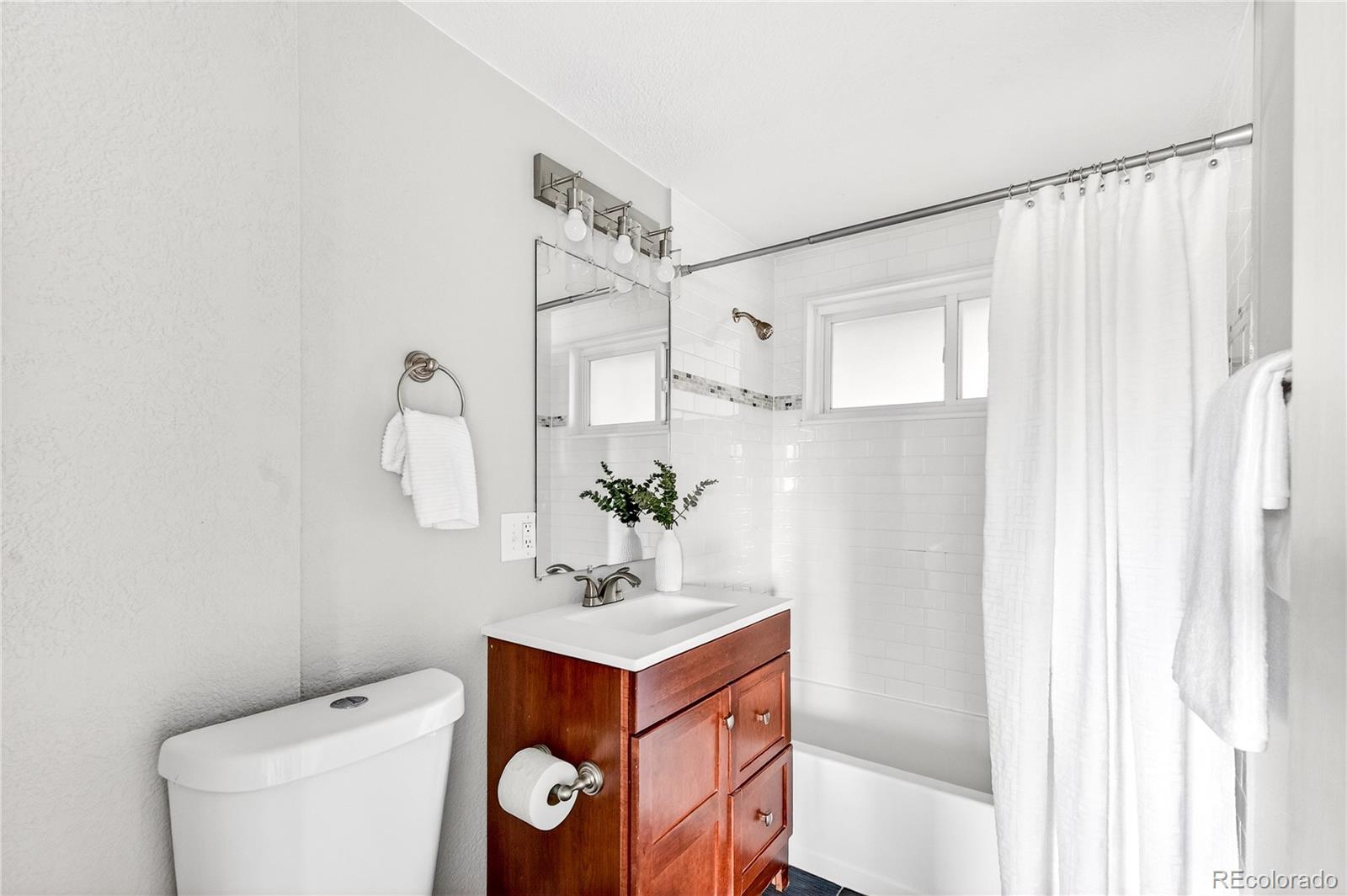 5246 Pierce Street Arvada, CO 80002 - Photo 10 of 30 a bathroom with a toilet sink and mirror