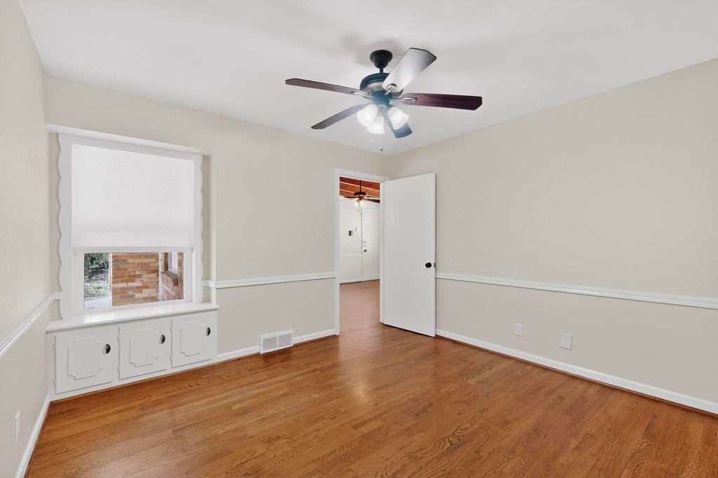 2120 Healey Drive Dallas, TX 75228 - Photo 34 of 39 an empty room with wooden floor chandelier fan and windows