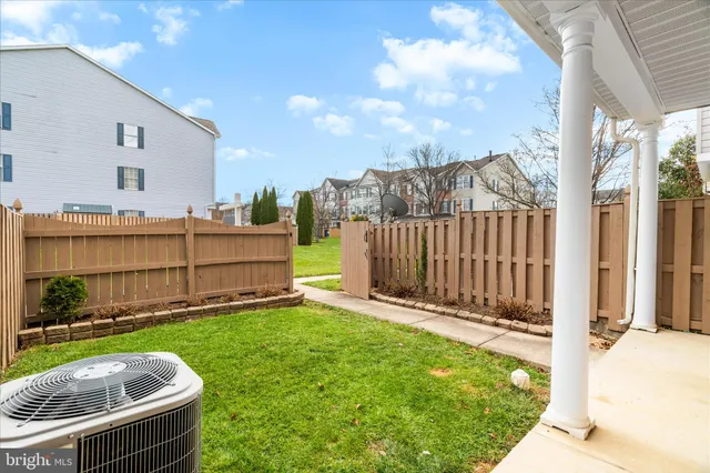 a view of a backyard with a tub and wooden fence