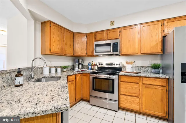 a kitchen with stainless steel appliances granite countertop a stove microwave and sink