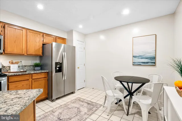 a kitchen with stainless steel appliances granite countertop a refrigerator and a stove top oven