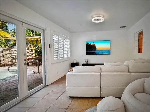 a living room with furniture a floor to ceiling window and a flat screen tv