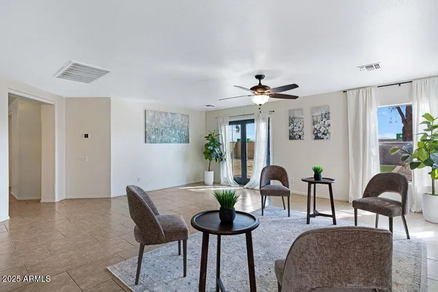 a kitchen with stainless steel appliances a table chairs refrigerator and microwave