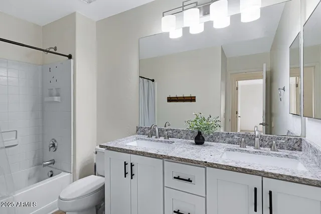a view of a livingroom with a ceiling fan & windows