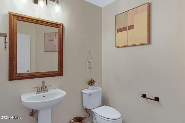 a living room with flat screen tv on dresser and a window