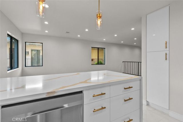 a view of a hallway that has a two couches and chandelier