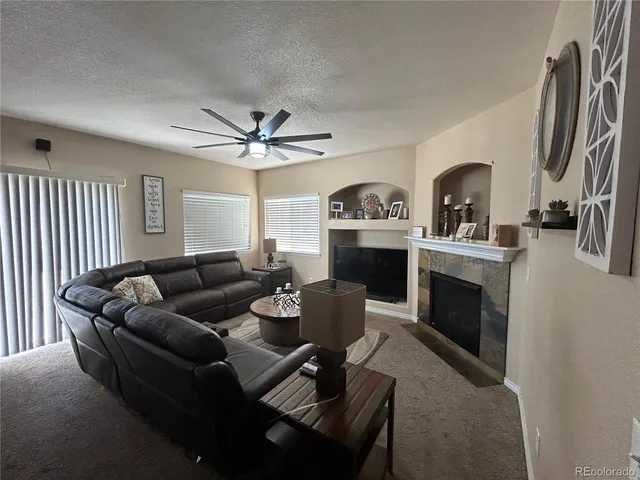 a living room with furniture a fireplace and a flat screen tv