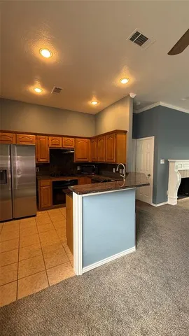 a kitchen with stainless steel appliances kitchen island granite countertop a refrigerator a sink and a stove