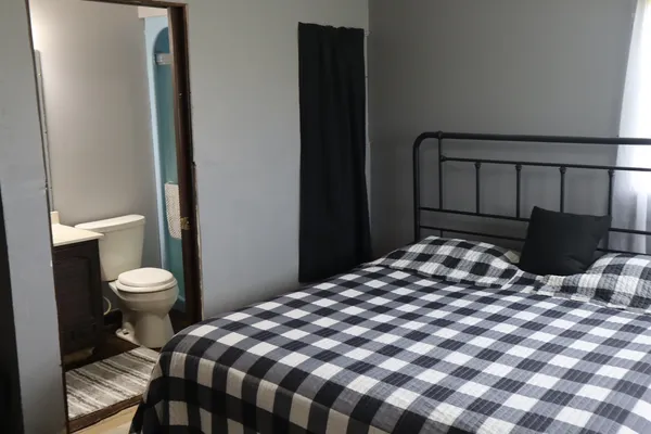 a bedroom with a bed and painting on the wall