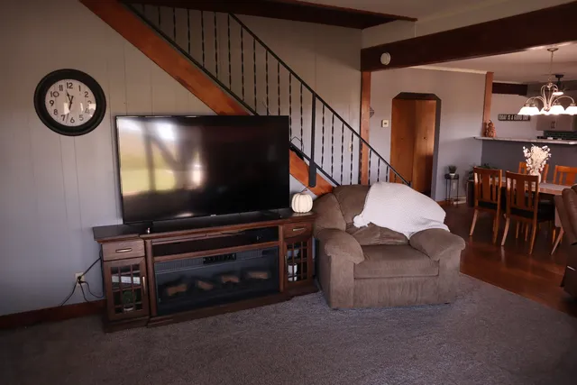 a living room with furniture a flat screen tv and a wall painting