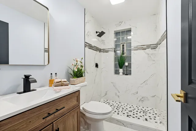 a bathroom with a sink a toilet and shower