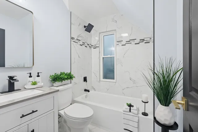 a bathroom with a sink a toilet a mirror and shower