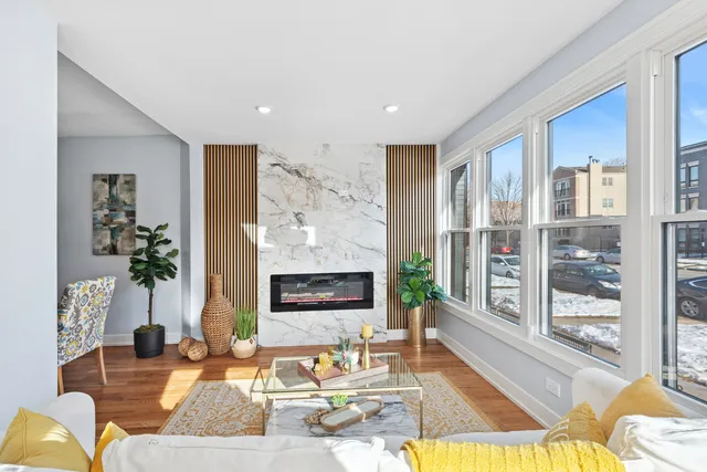 a living room with fireplace furniture and a floor to ceiling window
