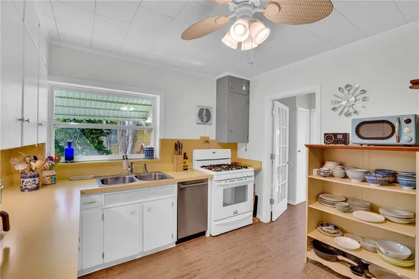 a view of a kitchen sink and dishwasher stove with wooden floor