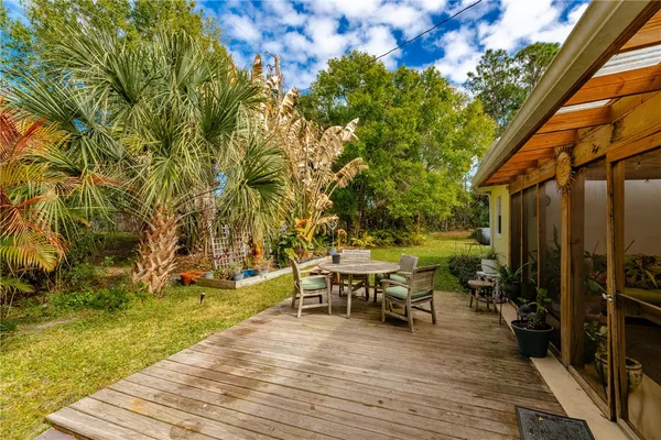 a view of a patio with table and chairs with wooden floor and fence