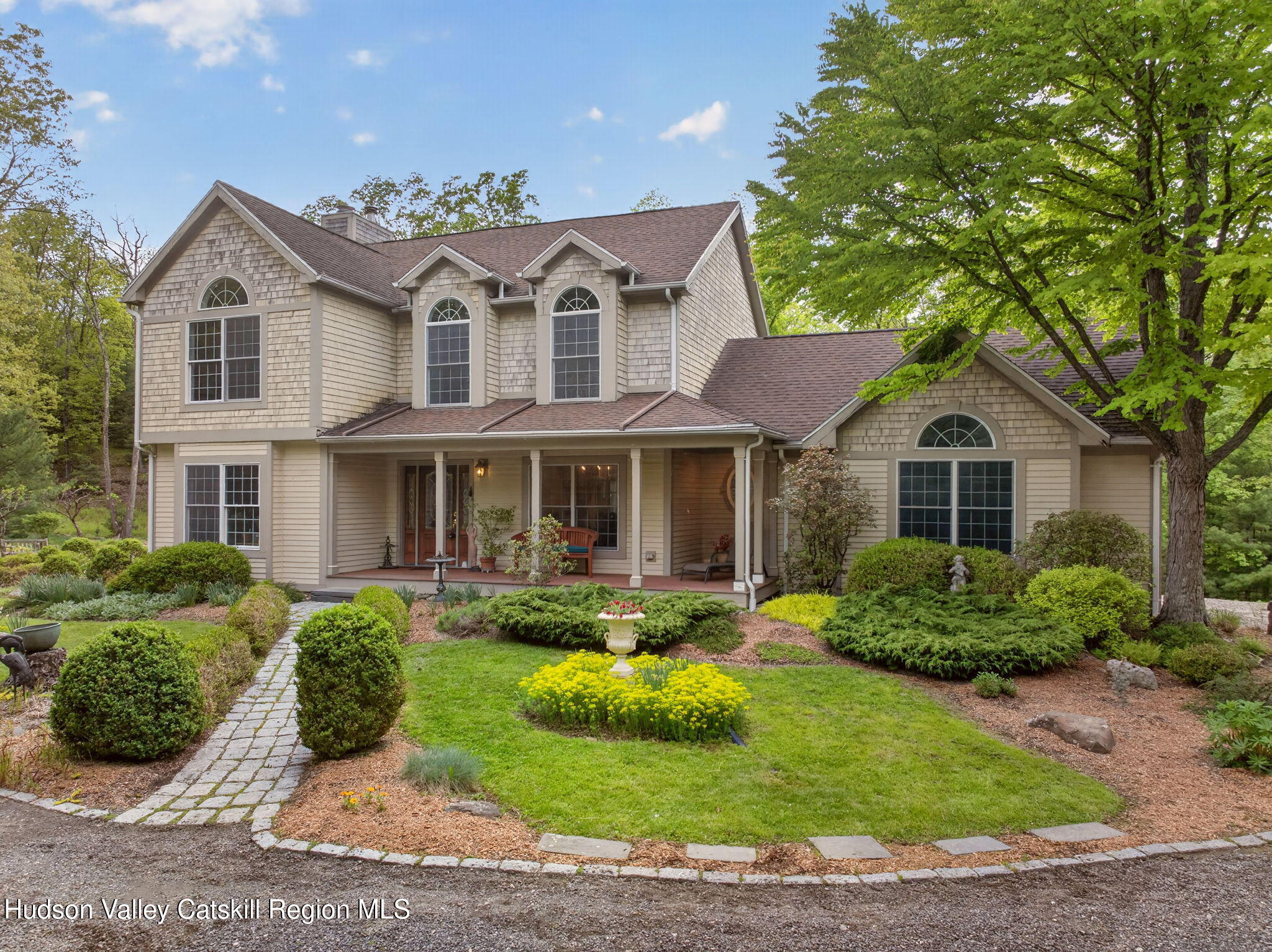 a front view of a house with a yard and potted plants