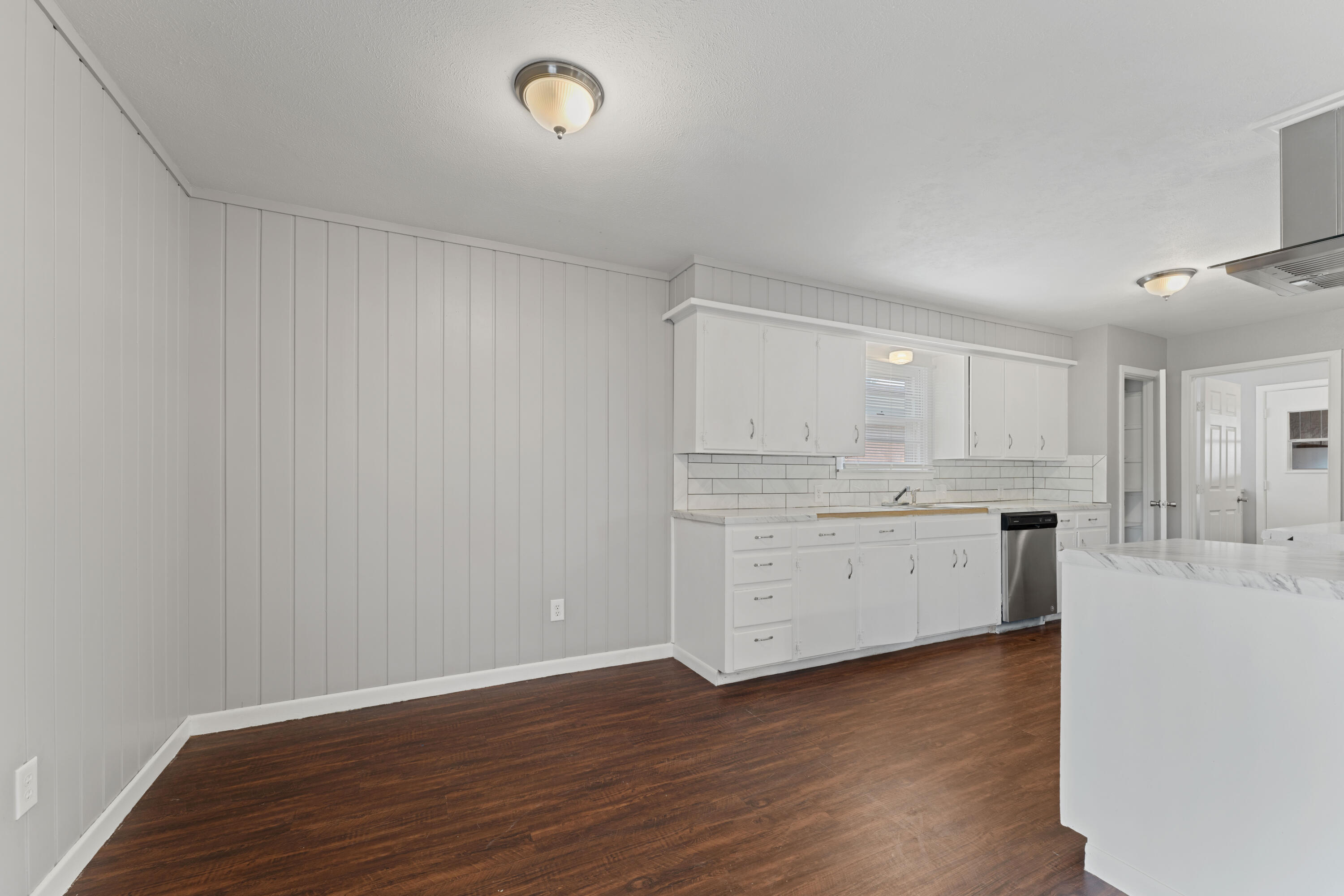 4609 31st Street Lubbock, TX 79410 - Photo 8 of 21 a room with kitchen island a sink wooden floor and white cabinets
