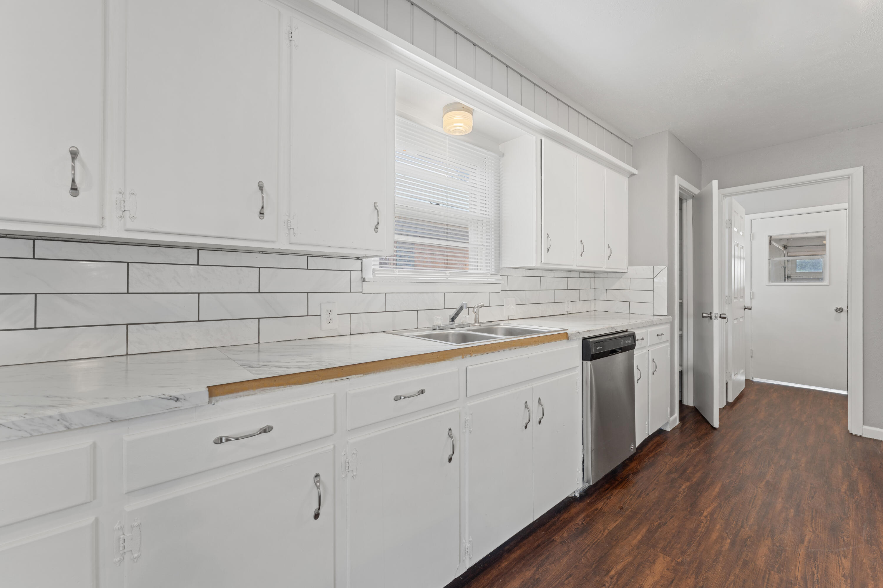4609 31st Street Lubbock, TX 79410 - Photo 9 of 21 a kitchen with granite countertop white cabinets and white appliances