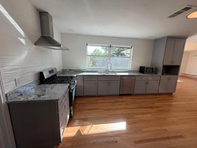 a kitchen with stainless steel appliances granite countertop a sink stove and refrigerator