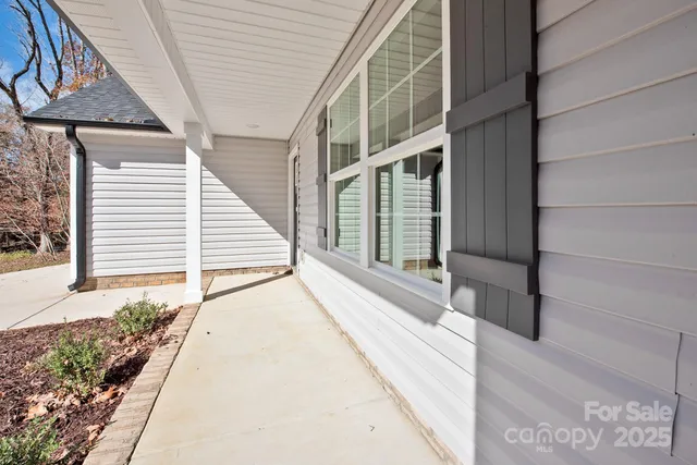 a view of an house with a floor to ceiling window and potted plants