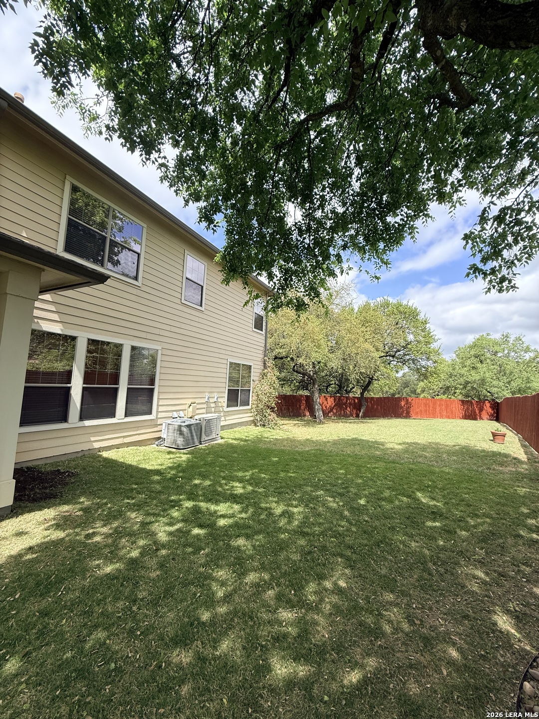 101 Rattlesnake Bluff Boerne, TX 78006 - Photo 19 of 28 a backyard of a house with large trees and plants