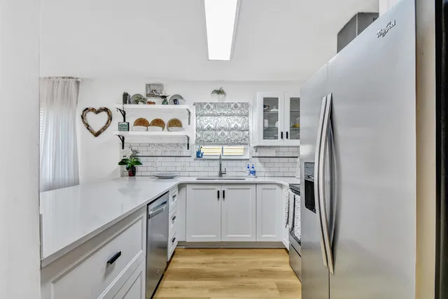 a kitchen with stainless steel appliances a white cabinets and sink