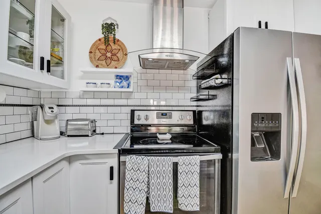 a kitchen with stainless steel appliances granite countertop a refrigerator and a stove