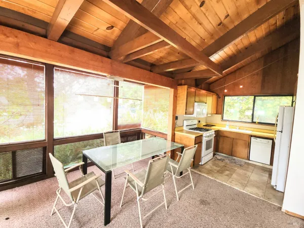 a dining room with furniture large windows and wooden floor